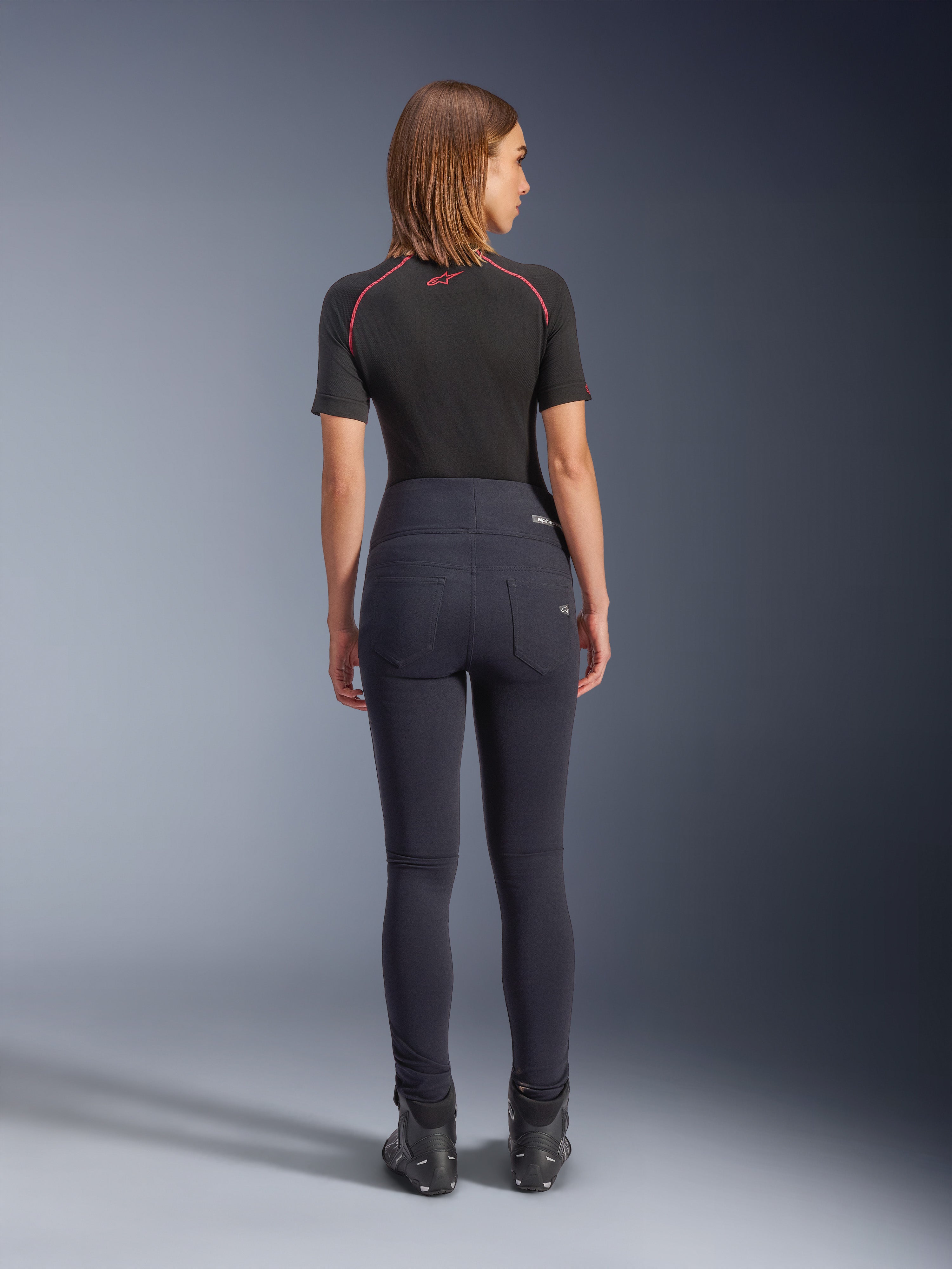 Alpinestars Stella Flex-AST leggings i sort, højtaljede motorcykelbukser til kvinder, set bagfra med skinny fit og baglommer, båret med sort kortærmet top og kørestøvler, urbant køreudstyr