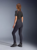 Alpinestars Stella Flex-Ast leggings til kvinder, sort, set bagfra viser højtaljet pasform og baglommer, båret med et sort kortærmet basislag med røde detaljer og sorte motorcykelsko, urbant moderne motorcykeludstyr