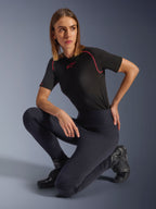 Kvinde iført Alpinestars Stella Flex-AST leggings, sorte højtaljede skinny motorcykel-leggings med harmonika-knæpaneler, stylet med en sort kortærmet performance-T-shirt med lyserøde syninger og kørestøvler.