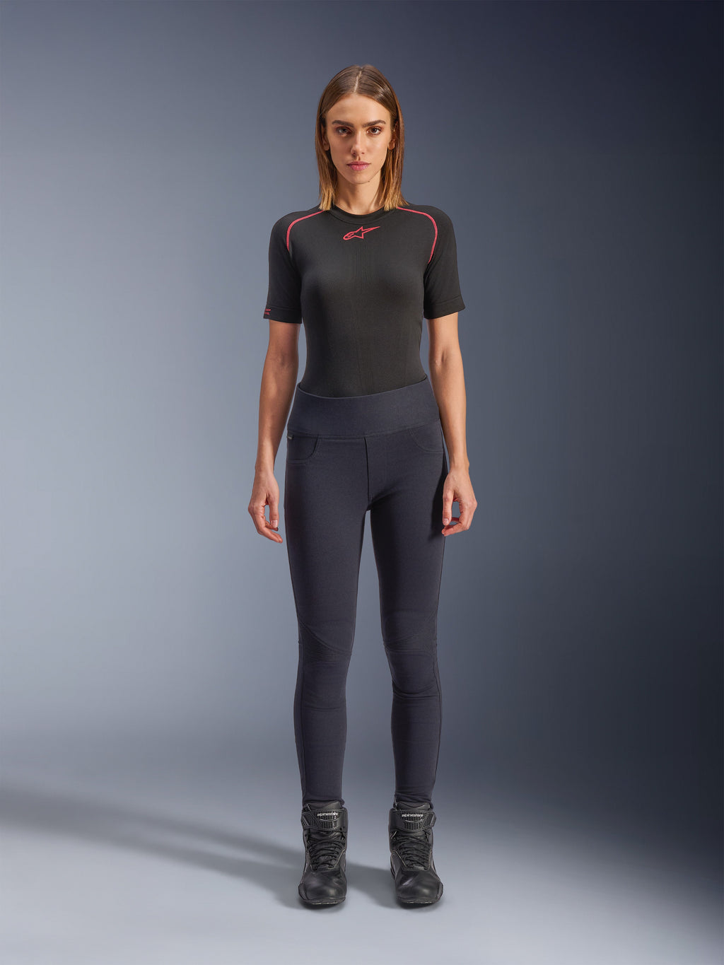 Alpinestars Stella Flex-AST leggings, urbane motorcykel-leggings til kvinder i sort, skinny højtaljet design båret med en sort kortærmet teknisk top og sorte motorcykelstøvler, med harmonika-knæpaneler og et moderne minimalistisk look