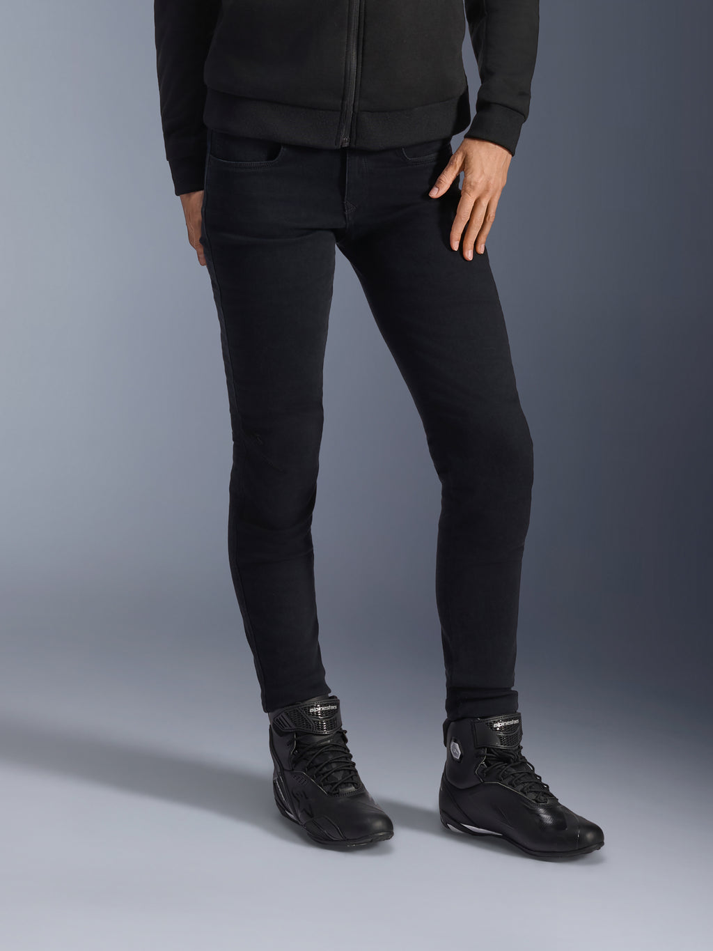 Alpinestars Daisy V3 motorcykeljeans til damer, Rinse Black, slim-fit motorcykeljeans, kombineret med sorte high-top ridestøvler og hættetrøje med lynlås, strømlinet monokrom urban styling