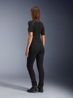 Alpinestars Banshee Leggings til kvinder, sort, set bagfra med tætsiddende anatomisk strækpasform og baglommer, båret med en sort kortærmet top og motorcykelstøvler, stilfuldt urbant motorcykeludstyr til kvinder