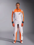 Alpinestars KMX-9 V3 Graphic 6 dragt, kartingdragt, hvid, orange og sort, med et sort nistret mønster, bæres med matchende orange og sorte racerhandsker og sko, beskyttende motorsport-heldragt med iøjnefaldende logoer og atletisk design