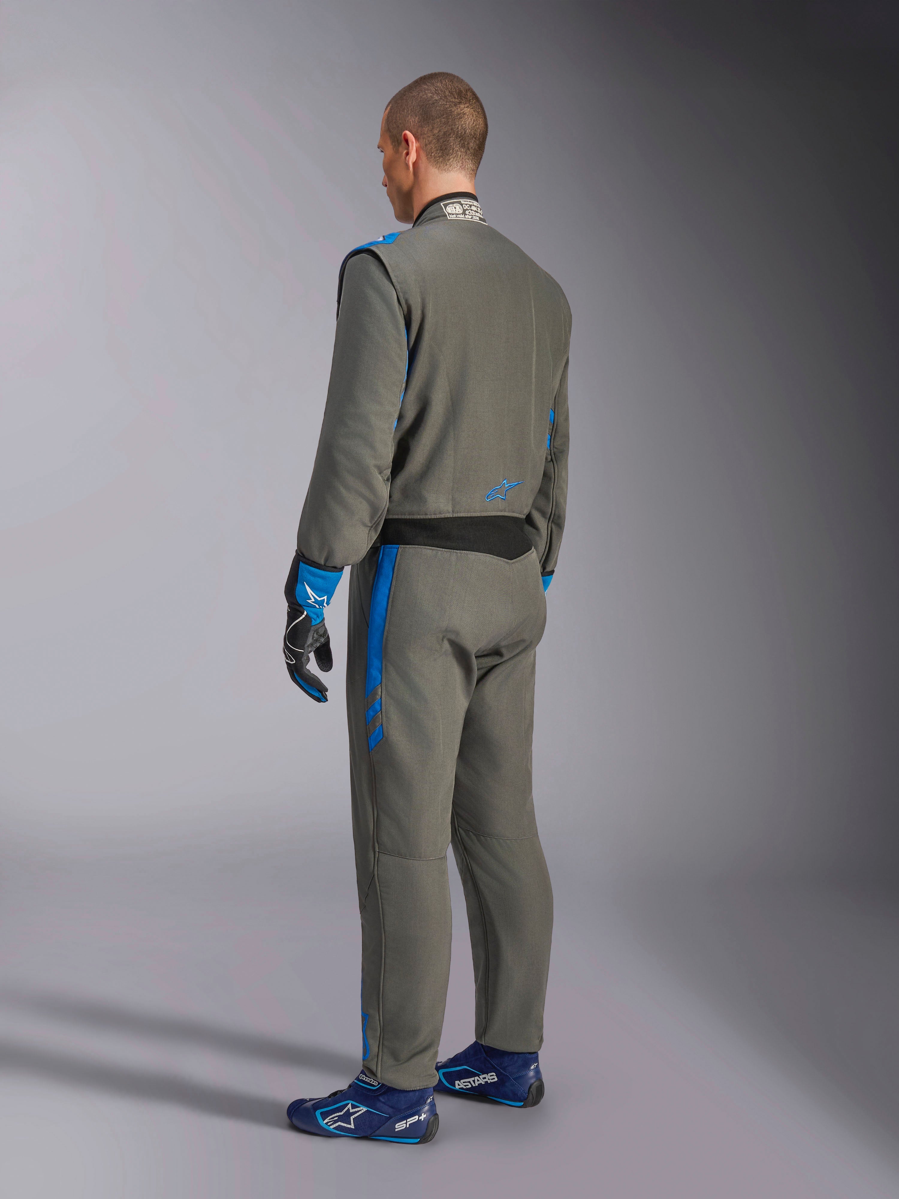 Alpinestars GP Race V3 Suit FIA, køredragt til biler, Antracitblå, set bagfra af model iført den grå heldragt med blå detaljer, matchende blå handsker og køresko, professionelt motorsportsudstyr