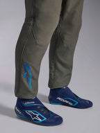Alpinestars GP Race V3 Køredragt FIA, Anthracite Blue bilsportskøredragt, nærbillede af underben med et blåt broderet Astars-logo ved anklen, kombineret med navy- og cyanfarvede kørestøvler, professionelt beskyttelsesudstyr til motorsport
