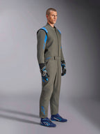Alpinestars GP Race V3-køredragt FIA i Anthracite Blue, ét-delt autoracerdragt båret af en mandlig model, med klare blå detaljer på skuldre og ankler, kombineret med matchende racerhandsker og blå racersko, professionelt motorsportsudstyr.