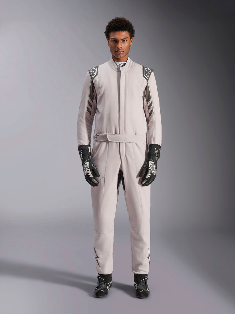 Alpinestars GP Race V3 Køredragt FIA i Silver Anthracite, etdelt bilsportsdragt båret af en model, med mørkegrå epauletter og detaljer, kombineret med sorte racerhandsker og støvler, professionelt motorsport-beskyttelsesudstyr.