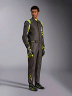 Alpinestars GP Race V3 Køredragt FIA, bilvæddeløbsdragt, sort og neongul, båret af en model med matchende racerhandsker og støvler, med markante gule detaljer på skuldre og ben, professionelt motorsportudstyr