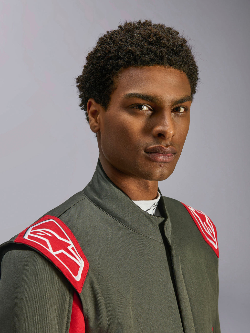 Alpinestars GP Race V3 køredragt FIA, auto-racerdragt, antracit rød, nærbillede af overkrop og hoved, med røde skulderepauletter med hvidt Alpinestars-logo, høj krave og gråt twill-materiale