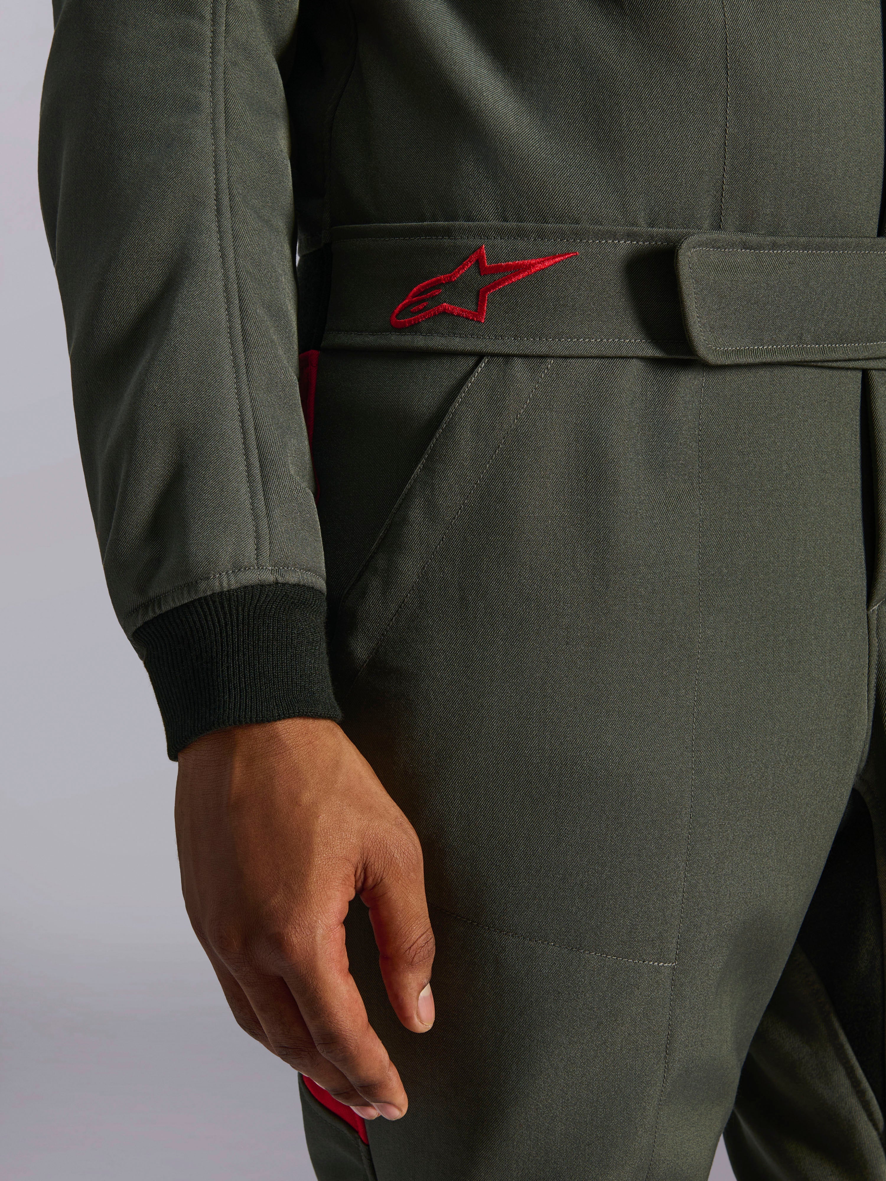 Alpinestars GP Race V3 køredragt FIA, autodragt, antracitgrå og rød, nærbillede af det justerbare bælte i taljen med et rødt broderet logo og sort ribstrikket ærmemanchet på tekstureret twill-stof
