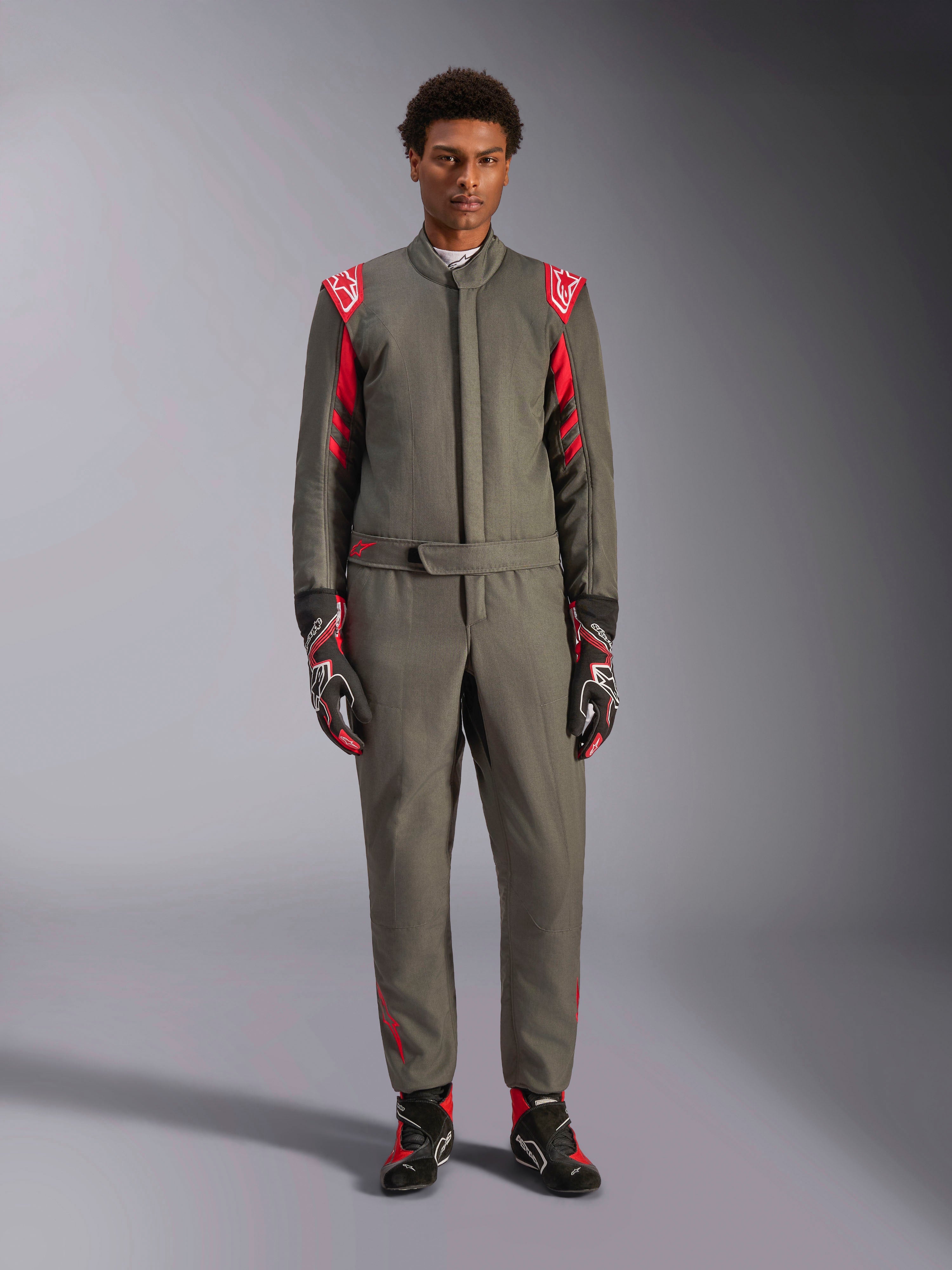 Alpinestars GP Race V3 Køredragt FIA, bilsportsdragt, antracit-rød, båret af en mandlig model med matchende handsker og støvler, med røde skulder-epauletter og branding, professionelt motorsportudstyr til præstationskørsel.