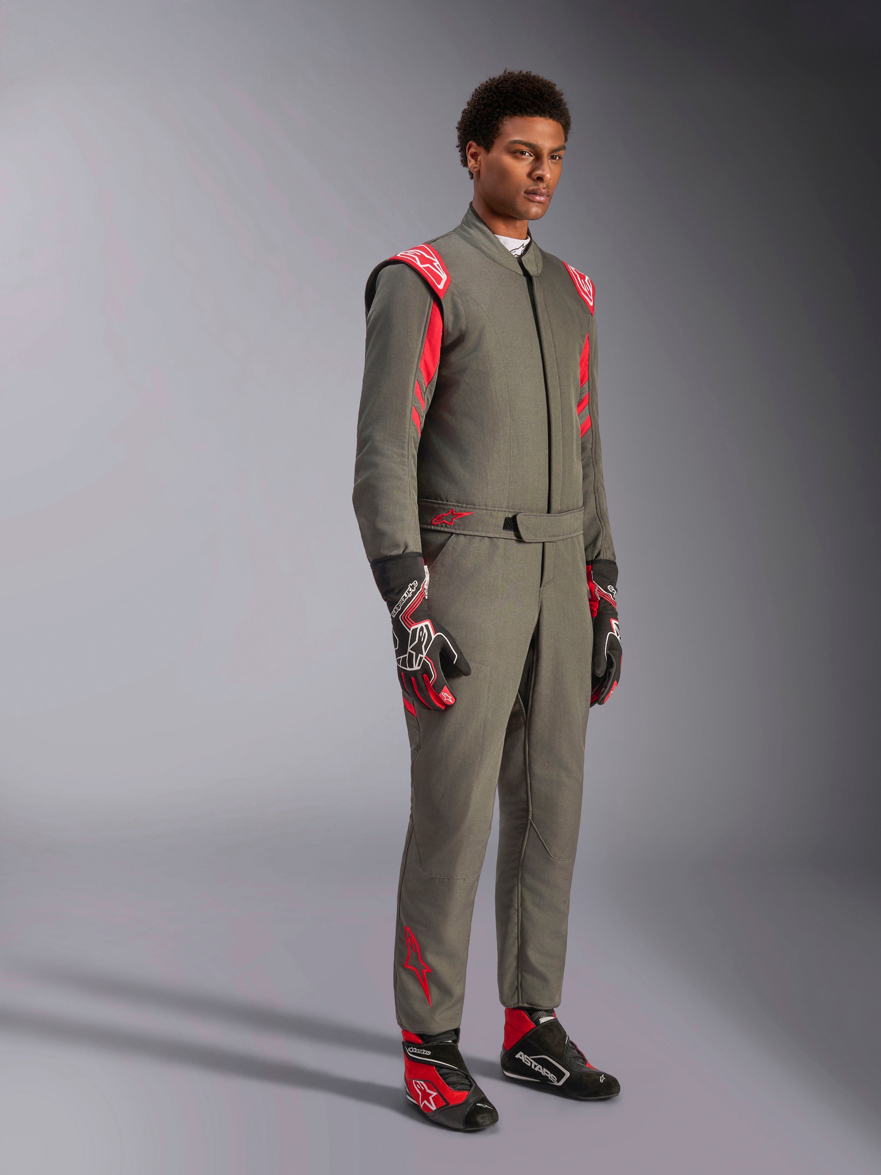 Alpinestars GP Race V3 Suit FIA, antracitgrå og rød køredragt til motorsport, båret med matchende racerhandsker og -sko, med røde skulder-epauletter og branding, strømlinet tolags teknisk design til motorsport