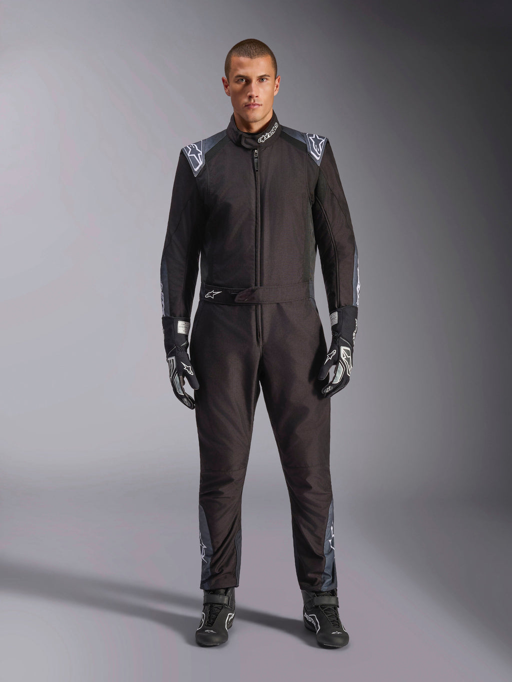 Alpinestars KMX-5 V3-dragt, kartingdragt, Black Dark Shadow, helkropsvisning af en model iført dragten med matchende handsker og støvler, mørkegrå detaljer og hvide Alpinestars-logoer på skuldre og bælte, professionelt motorsportsudstyr.
