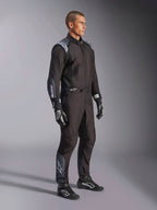 Alpinestars KMX-5 V3 dragt, kartingdragt i Black Dark Shadow, båret med matchende sorte racerhandsker og sko, med laserskårne perforeringer og tekniske mesh-paneler, strømlinet dobbeltlagskonstruktion med hvid branding til professionel motorsport
