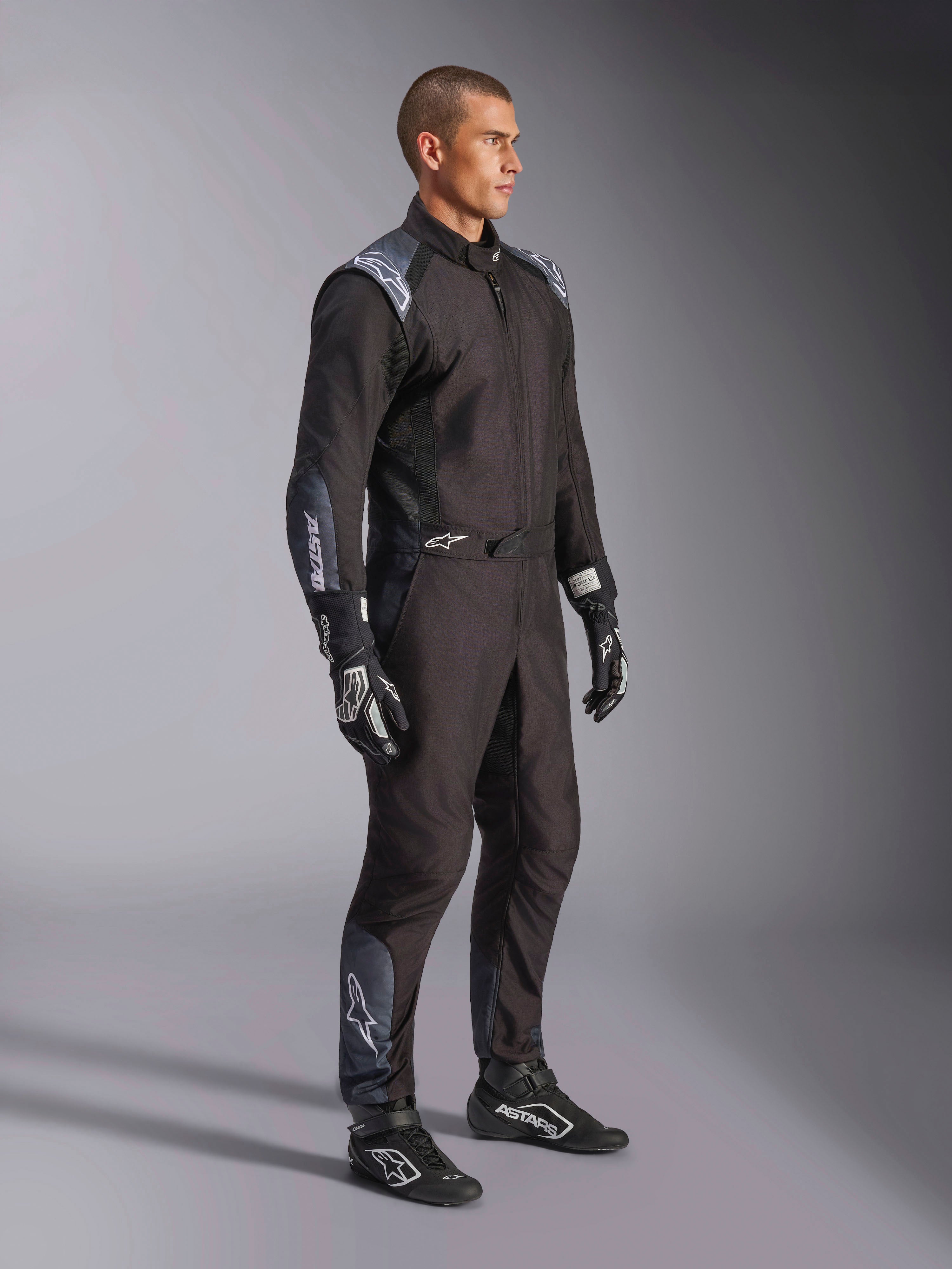 Alpinestars KMX-5 V3 dragt, kartingdragt i Black Dark Shadow, båret med matchende sorte racerhandsker og sko, med laserskårne perforeringer og tekniske mesh-paneler, strømlinet dobbeltlagskonstruktion med hvid branding til professionel motorsport