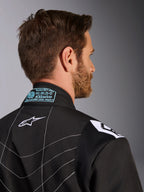 Alpinestars KMX-9 V3 dragt, sort og hvid, tætbillede af den bagerste krave og skulderområdet, med lyseblå broderede FIA-homologeringsdetaljer, hvidt stjernelogo og hvide kontraststikninger.