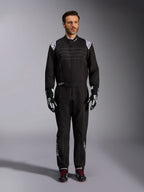 Alpinestars KMX-9 V3 dragt, sort og hvid kartingdragt, fuldlængde visning på en model, hvide skulderlogoer og detaljer, stylet med sort-hvide racinghandsker og sorte sko med røde snørebånd, atletisk-almindelig pasform til professionelt kartingudstyr.