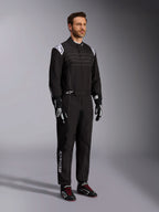 Alpinestars KMX-9 V3 kartingdragt, sort og hvid, mandlig model iført fuld racerdragt med hvidt Alpinestars-logo på skuldrene, kombineret med sort-hvide racerhandsker og sorte kartingsko med røde snørebånd, studieoptagelse der viser front- og sideprofil