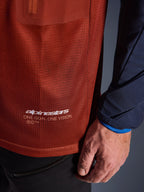 Alpinestars Maxdura Dual Jersey, adventure motorcykeltrøje, rustbrun og Mood Indigo, nærbillede af mesh-stoffet på torsoen og det mørkeblå vævede ærme, hvid Alpinestars 'One Goal One Vision' branding på den nederste søm.