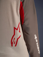 Alpinestars Maxdura Dual Jersey, Aluminum Walnut, nærbillede der viser den ventilerede mesh-torso med et rødt stjernelogo og et brunt slidstærkt ærme med et hvidt Alpinestars-navnetræk, teknisk beklædning til adventure- og dual-sport-motorcykelkørsel
