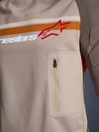 Alpinestars Maxdura Dual Jersey, Aluminum Walnut, nærbillede af mesh-overkroppen, vandret orange og hvid stribe med rødt logo, lodret brystlomme med lynlås, adventure motorcykelbeklædning