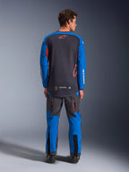 Alpinestars Maxdura Dual Jersey i Deep Gray og Royal Blue, set bagfra med fuld mesh-torso og orange stjernelogo, kongeblå ærmer med hvid branding, båret med matchende grå og blå adventure-bukser, højtydende udstyr til dual-sport-kørsel
