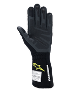 Alpinestars Tech-1 ZX V4 Gloves, Auto Racing Gloves, Tar Gray and Black with Yellow Fluo logo, palm view showing textured 3D silicone grip and FIA/SFI safety certification labels, professional motorsport equipment