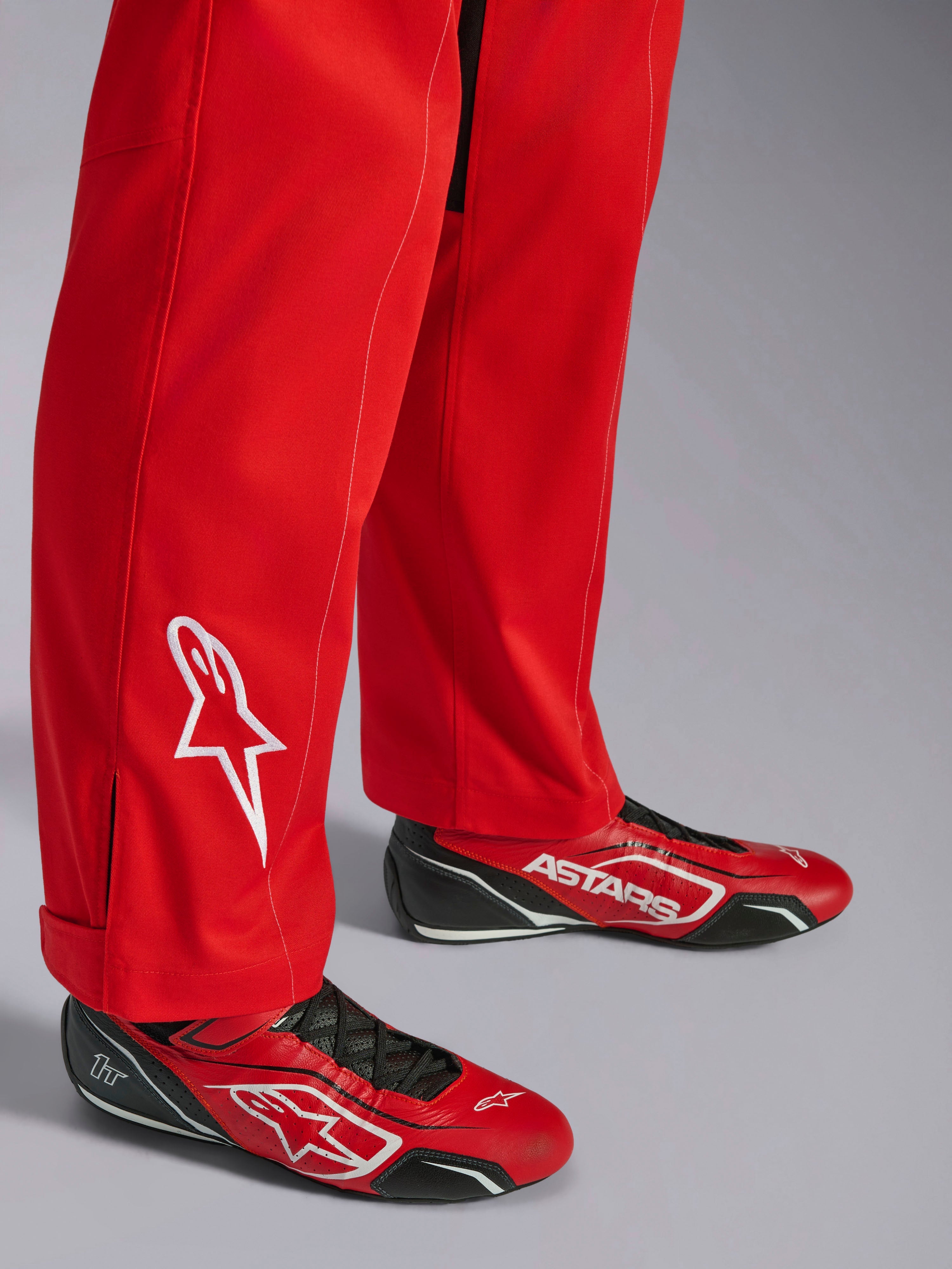 Alpinestars Kart Indoor V2 Køredragt, rød, detalje af underbenet med hvidt broderet stjernelogo, båret med matchende røde og sorte kartingsko, enkeltlags poly-bomuldstwill til rekreativ racing