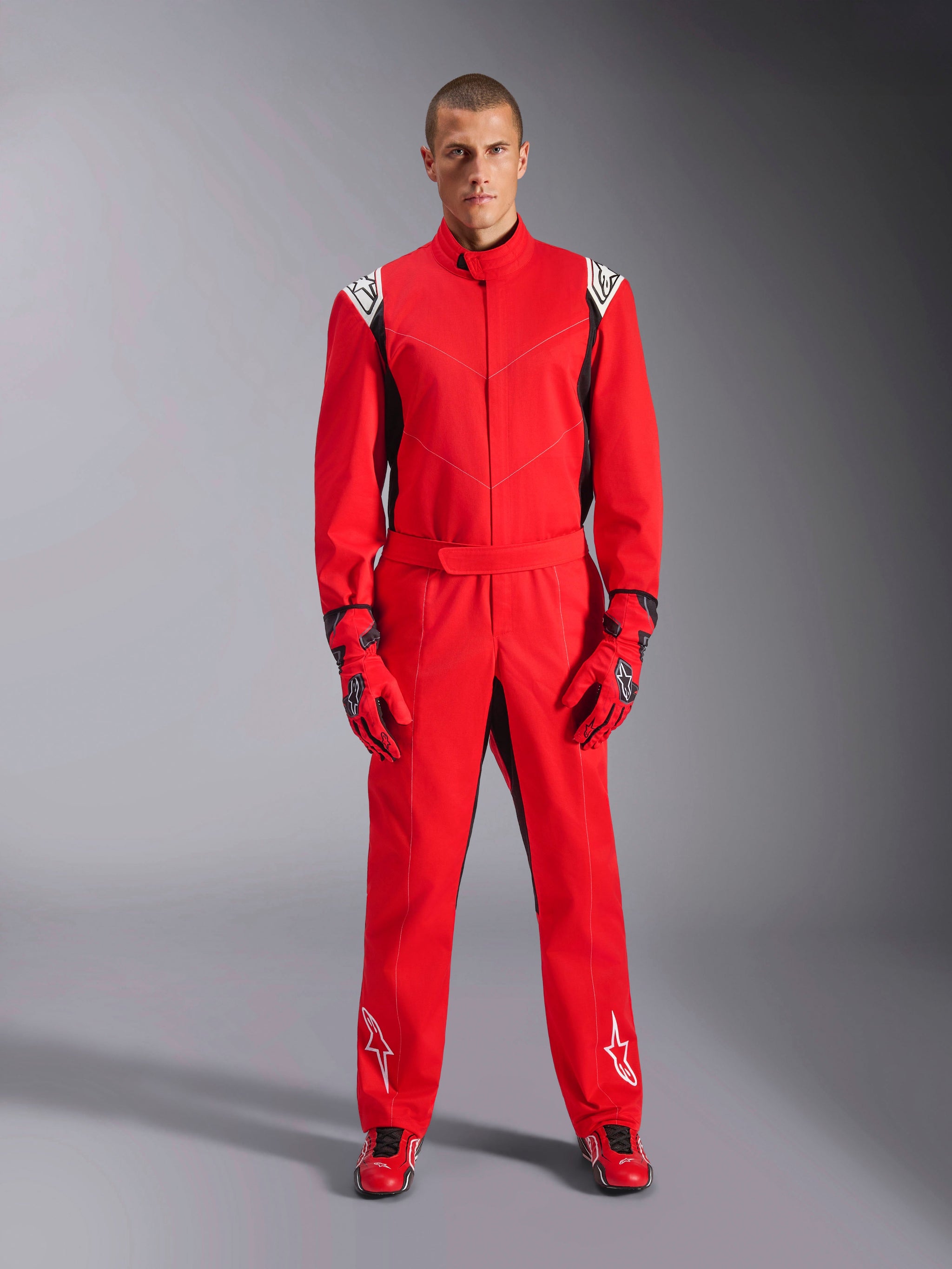 Alpinestars Kart Indoor V2 Suit, rød, gokartdragt i ét stykke, båret med matchende røde handsker og racersko, hvide logoer på skuldre og ben, sorte detaljer, strømlinet design til rekreativ karting