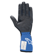 Alpinestars Tech-1 Race V4 Gloves, Black and Blue, interior palm view showing textured silicone grip pattern, extended blue cuff with FIA certification label and white Alpinestars logo, professional auto racing gear