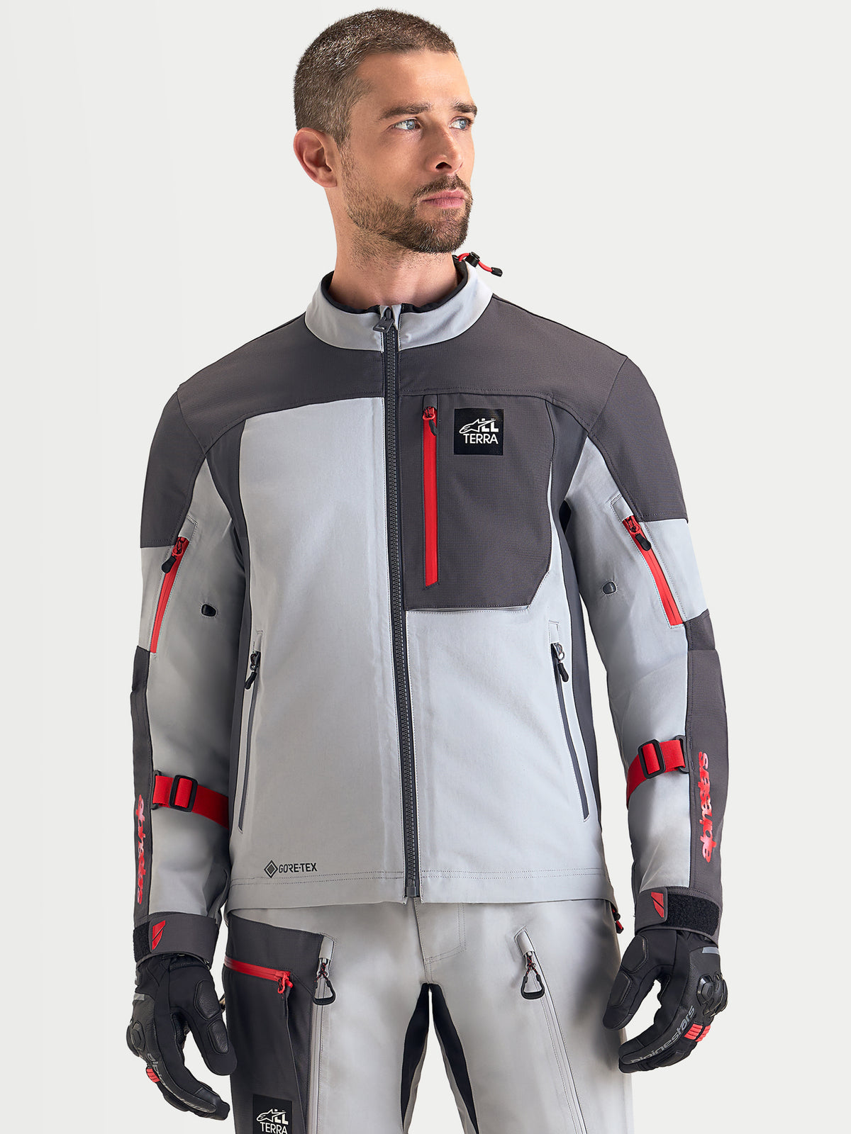 Alpinestars Arenis Gore-Tex Jacket, men's adventure touring motorcycle jacket in mid gray, deep gray, and black, front view worn by a model showing waterproof textile construction and zippered chest pocket