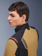 Alpinestars ST-7 2L GORE-TEX-jakke, motorcykeljakke, Gobi Brown og sort, sideprofil af en mand iført jakken, med orange branding på skulderen, høj krave med stødledningsjustering og Tech-Air-branding.