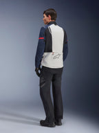 Model iført Alpinestars ST-7 2L GORE-TEX jakke i Ice Gray, Dark Blue og sort, set bagfra, lysegråt rygpanel med Alpinestars-logo, mørkeblå ærmer med rød stribe, sorte adventure-kørebukser og -støvler, motorcykel touring-udstyr