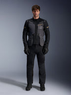 Mandlig model iført Alpinestars ST-7 2L GORE-TEX-jakke i Deep Gray Black Dark Khaki, med 'ALPINESTARS EXPLORATION EQUIPMENT'-branding på brystet, kombineret med matchende sorte kørebukser, handsker og støvler, studiebillede set forfra.