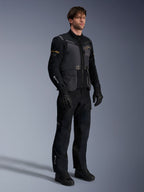 Mandlig model iført Alpinestars ST-7 2L GORE-TEX jakke i Deep Gray Black og Dark Khaki, sorte adventure-bukser og handsker, vandtæt lamineret yderskal med cargolommer og teknisk branding, ideel til adventure touring