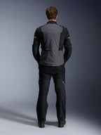 Alpinestars ST-7 2L GORE-TEX-jakke, Deep Gray Black og Dark Khaki, set bagfra på en model, adventure motorcykel touring-jakke med gråt rygpanel og sorte leddelte ærmer, båret med matchende sorte bukser.