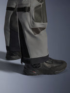 Alpinestars Nazca 3L GORE-TEX PRO bukser, adventure-motorcykelbukser, mørkegrå og sort, nærbillede af underben med lægvolumenjusteringer og Superfabric-forstærkninger, båret med sorte Alpinestars støvler, holdbart tekstil til ekstrem adventure-kørsel