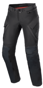 Alpinestars Stella ST-7 2L GORE-TEX bukser til damer, adventure touring motorcykelbukser, sort og mørkegrå, set forfra med cargolommer, magnetisk taljespænde, artikulerede knæ med beskyttelsespositionering og diskret Alpinestars-branding på låret.