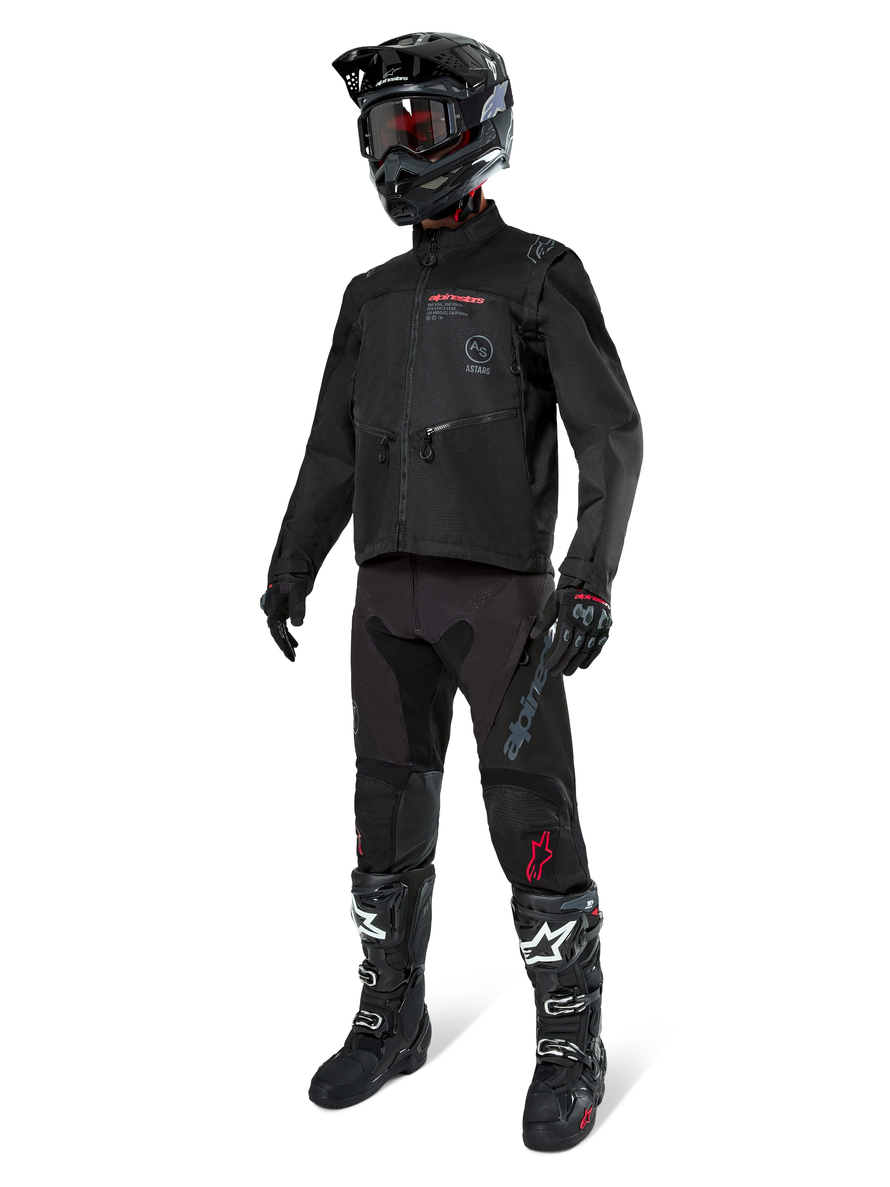 Motocross-kører i komplet racerudstyr, Alpinestars Pro-Dura-jakke i sort, sorte bukser med grå branding og røde detaljer, sort hjelm med goggles og sort-hvide motocross-støvler, koordineret outfit til enduro- og off-road-kørsel