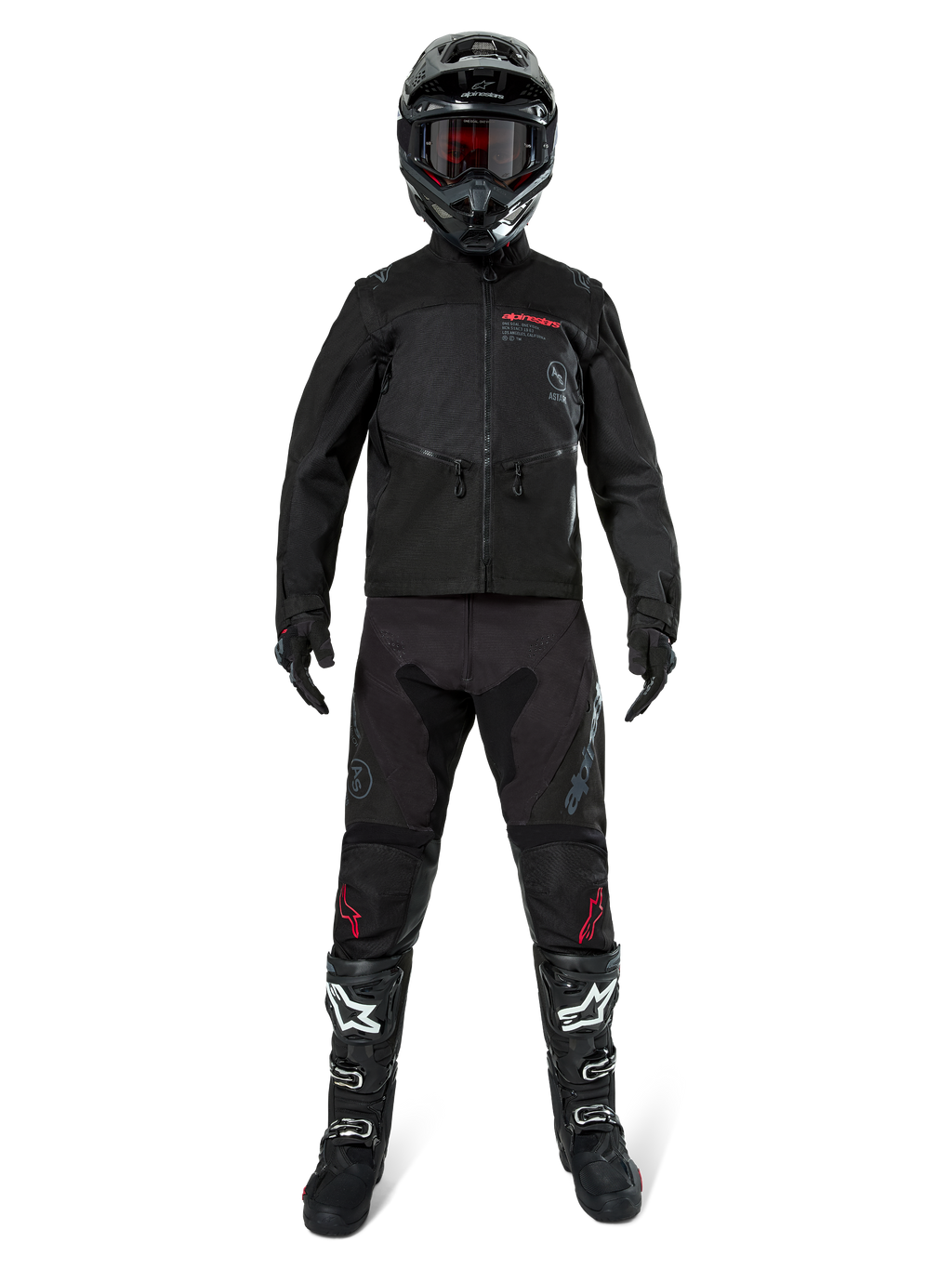 Alpinestars Pro-Dura jakke, sort off-road enduro-jakke, vist på en model med et komplet udstyrssæt inklusiv sort hjelm med røde goggles, sorte bukser med røde detaljer, sort-hvide støvler og sorte handsker, rally-inspireret robust design til terrænkørsel