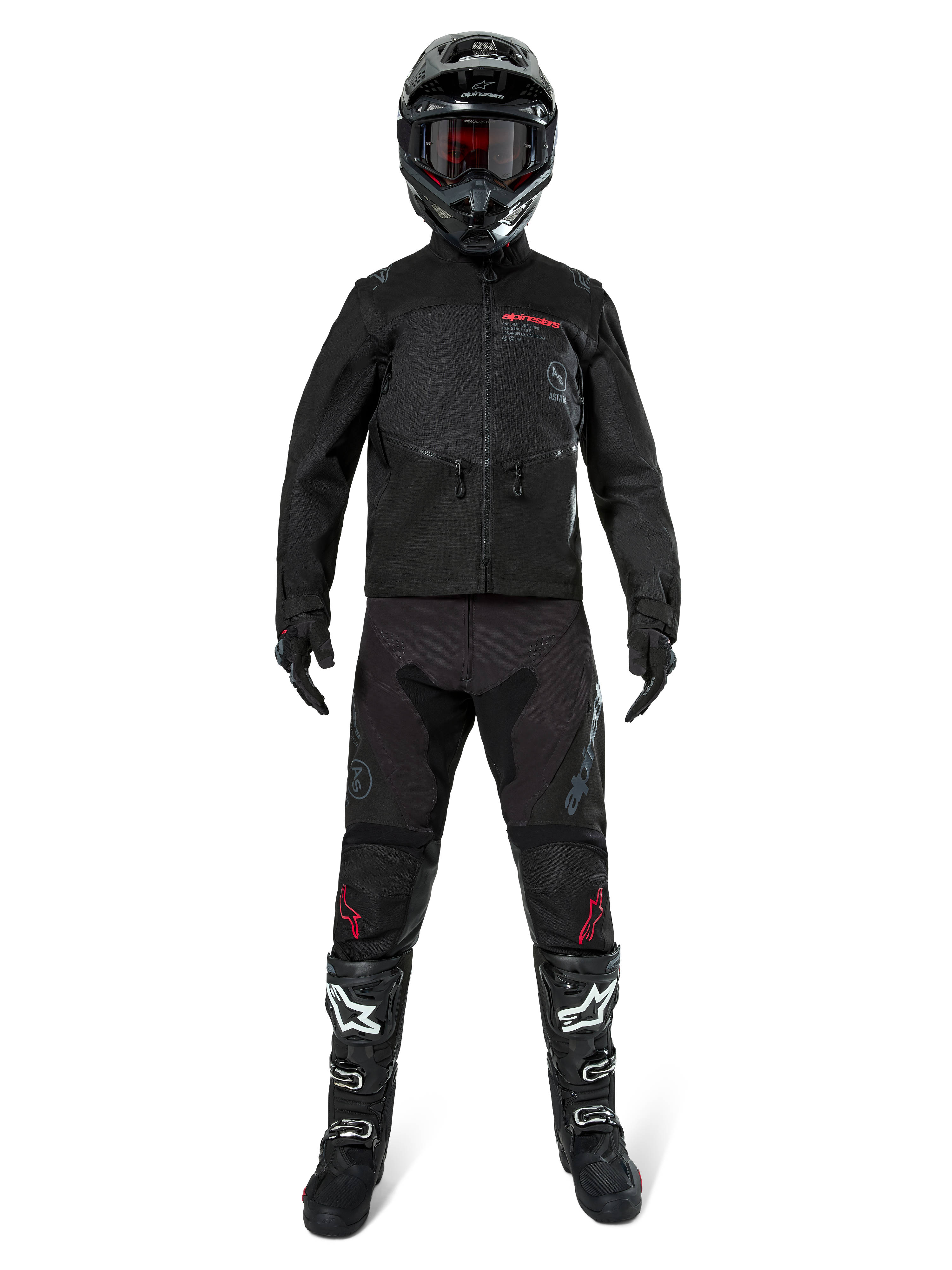 Alpinestars Pro-Dura jakke, sort off-road enduro-jakke, vist på en model med et komplet udstyrssæt inklusiv sort hjelm med røde goggles, sorte bukser med røde detaljer, sort-hvide støvler og sorte handsker, rally-inspireret robust design til terrænkørsel