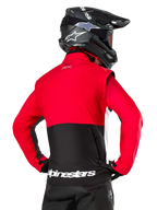 Alpinestars Pro-Dura jakke, off-road endurojakke, rød og sort med hvidt Alpinestars-logo på den nederste kant bagpå, set bagfra på en kører med en sort motocrosshjelm, rally-inspireret design til aggressiv trailkørsel