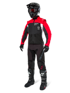 Alpinestars Pro-Dura jakke, off-road motorcykeljakke, sort, klar rød og hvid, vist med komplet racerudstyr inklusive sort hjelm med røde goggles, sorte bukser og sort-hvide støvler, slidstærkt tekstilsæt til enduro- og trailkørsel