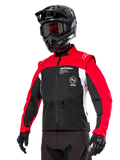 Alpinestars Pro-Dura jakke, off-road enduro motorcykeljakke, sort med klar rød og hvid farveblokering, båret af en kører med sort hjelm og goggles, med lynlåslommer foran og Alpinestars-branding, slidstærk tekstilkonstruktion til trail-kørsel
