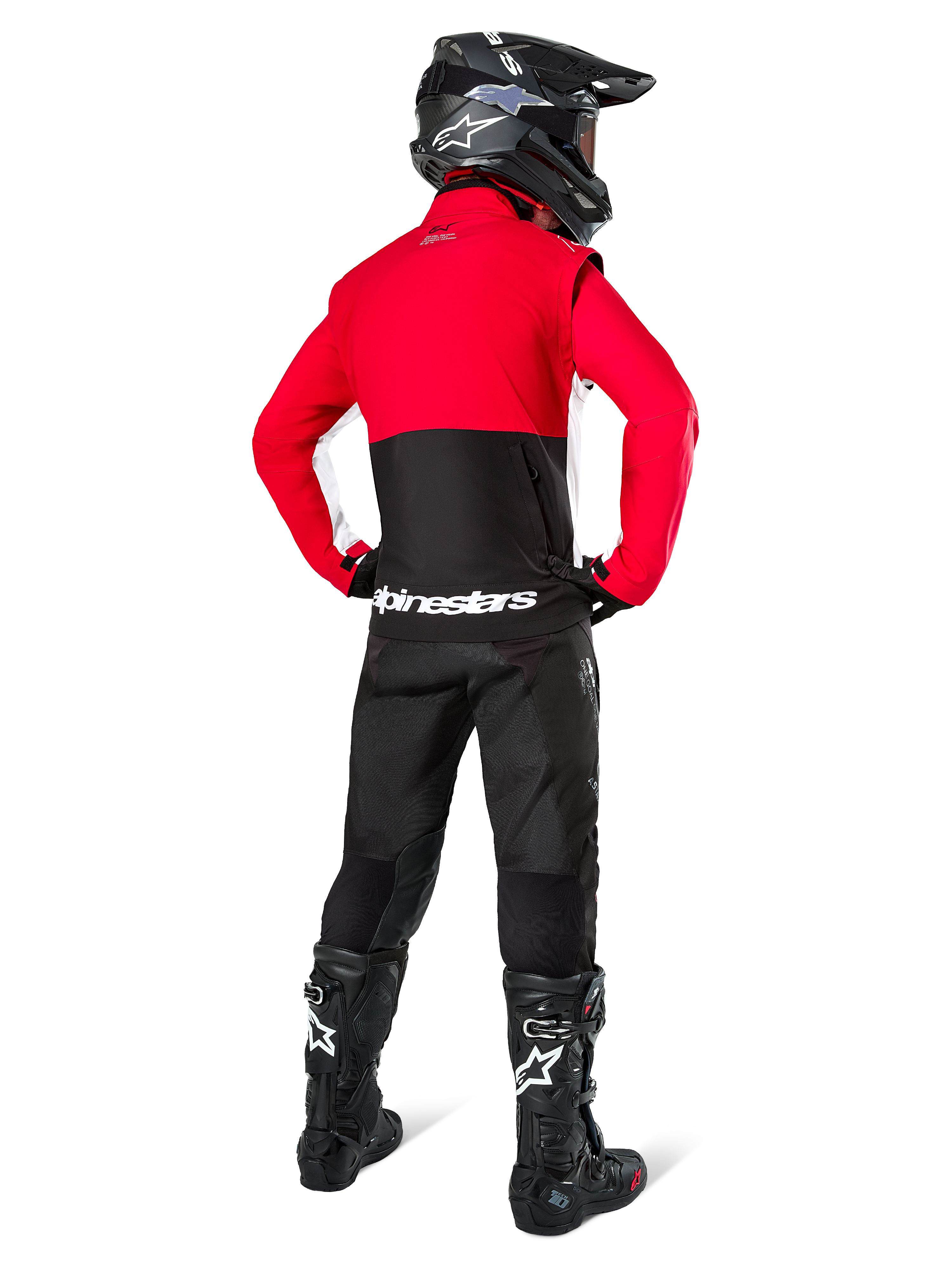 Motocross rider from behind wearing Alpinestars Lite-Dura Softshell Jacket, Black Bright Red and White, featuring a red upper panel and black lower section with white branding, paired with black pants, black helmet, and black boots, coordinated enduro outfit for off-road riding