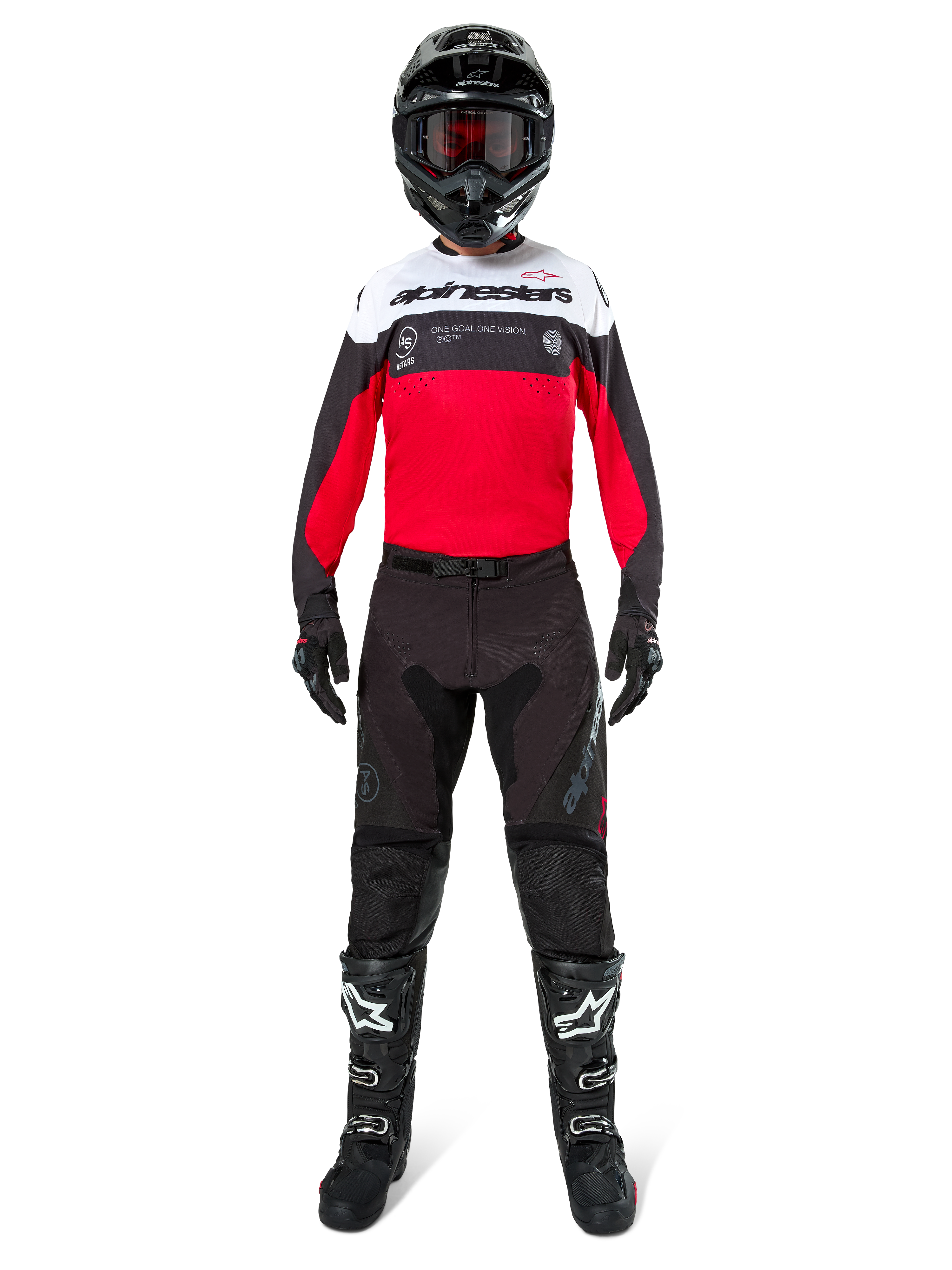 Motocross-kører iført Alpinestars Pro-Dura bukser i sort og magnet, kombineret med en rød, hvid og sort trøje, sort hjelm og sorte støvler, komplet off-road racing-udstyr, holdbart og letvægtsdesign til enduro-kørsel