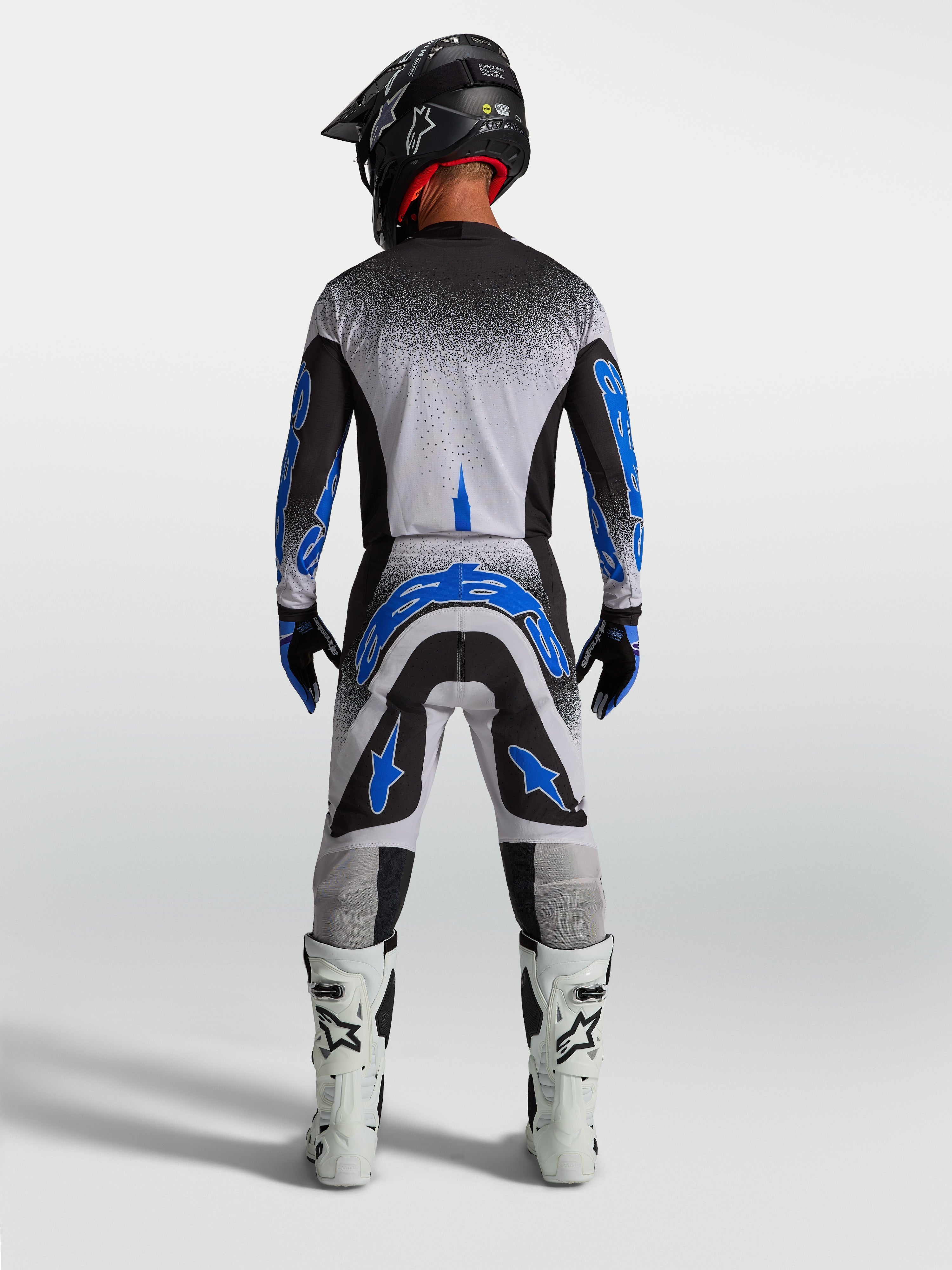 Alpinestars Supertech Hiten AFD Pants, men's motocross racing gear in blue and white, athletic rear view.