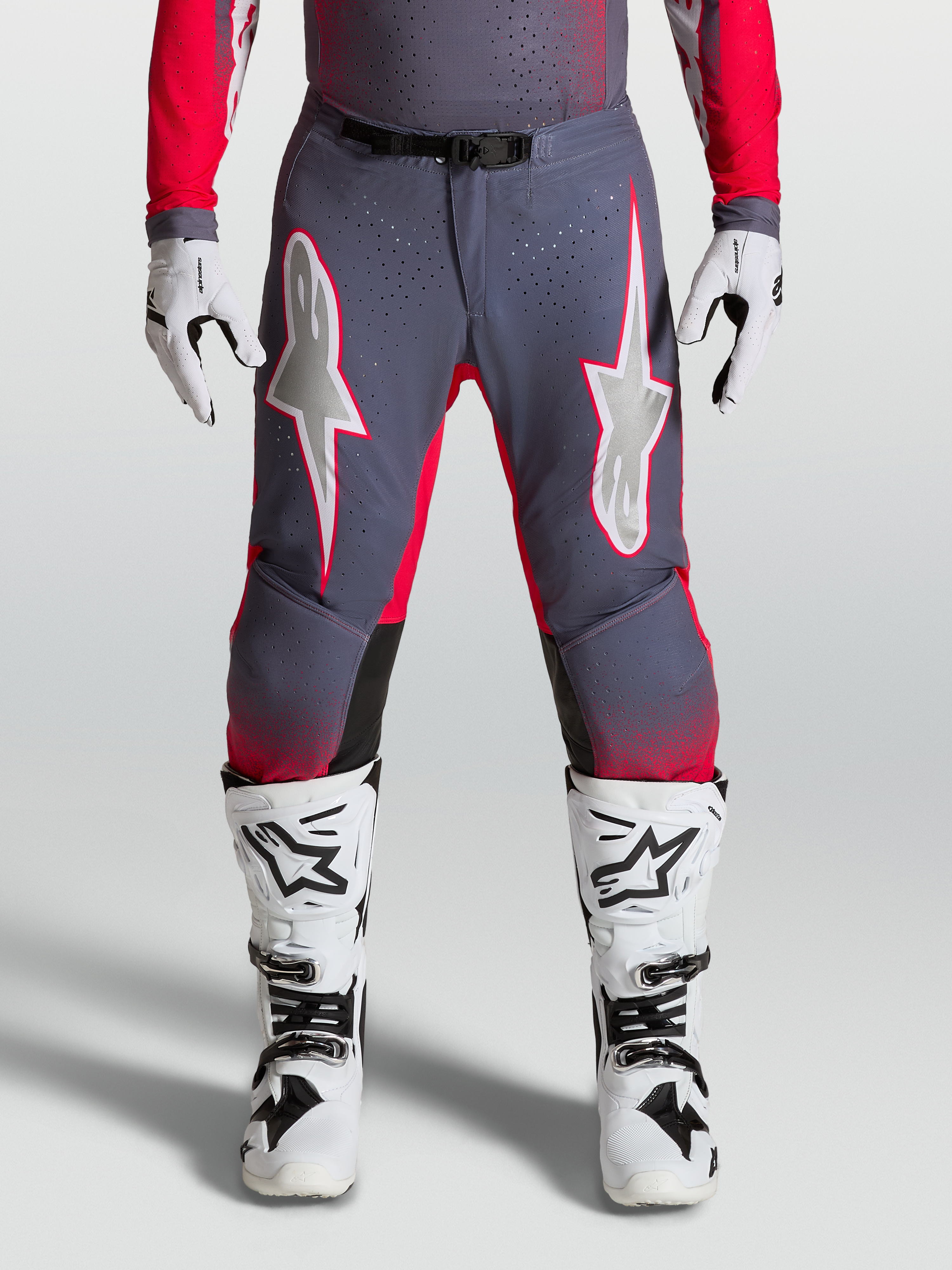 Alpinestars Supertech Hiten AFD Pants, high-performance Motocross gear in Graystone and Red Fluo with light lilac star graphics and perforated stretch panels.