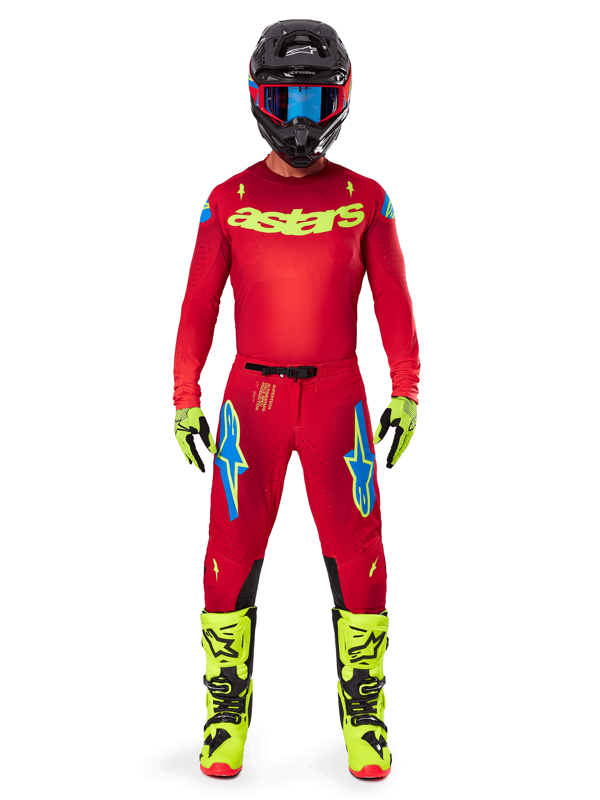 Motocross rider wearing complete racing gear, Red jersey with yellow fluo astars logo, Alpinestars 2025 Supertech Maker Pants in Bright Red and Yellow Fluo, featuring blue logos on thighs, yellow fluo gloves and boots, black helmet with blue goggles, coordinated pro-level motocross outfit