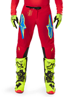 Alpinestars 2025 Supertech Maker bukser, motocrossbukser, rød og neon gul, med blå Astars-logoer på lårene, ventilerede perforeringer og sorte indvendige knæpaneler, båret med matchende neon gule støvler og handsker